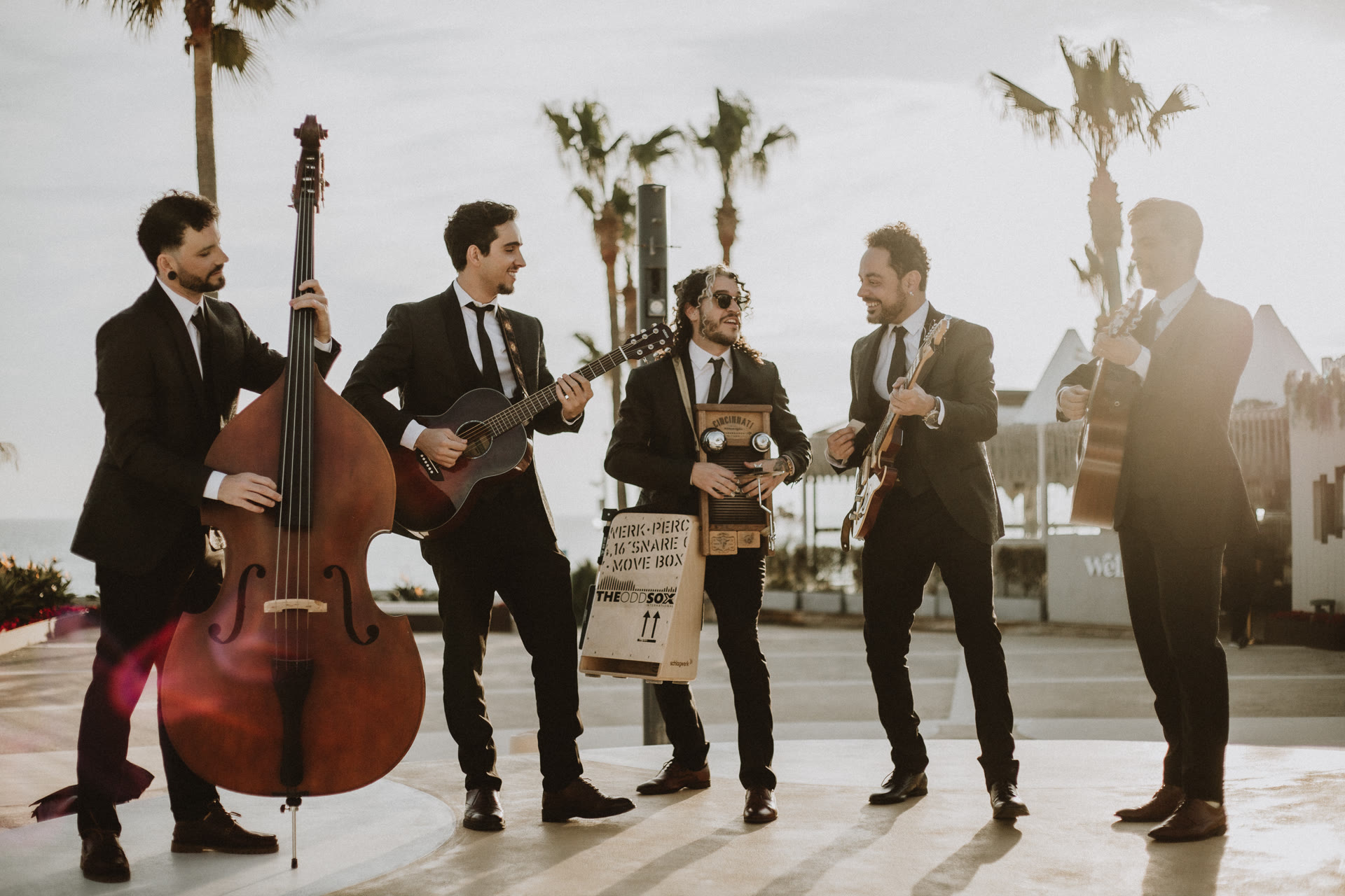 Band members playing acoustic instruments among wedding guests